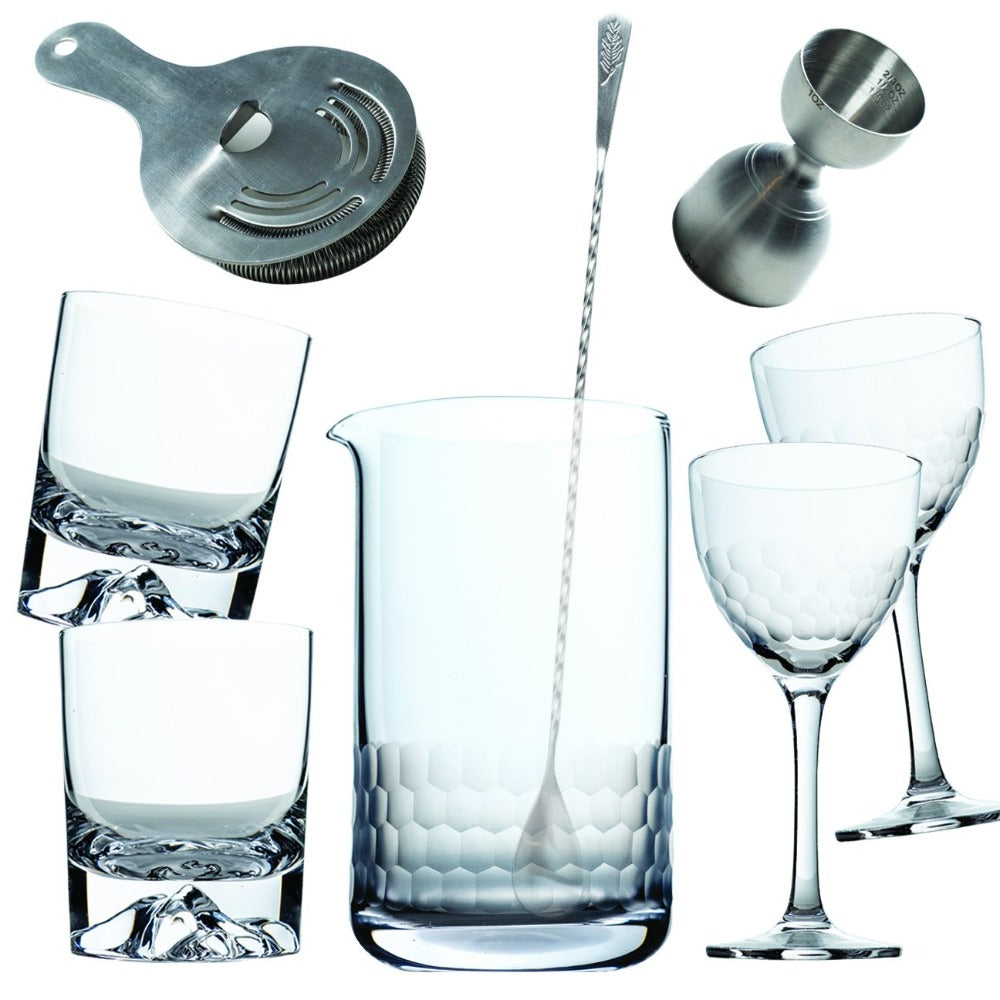 Amehla's eight piece cocktail set for bartenders and mixologist. one honeycomb mixing glass, barspoon, rounded double jigger, hawthorn strainer, two honeycomb nick and nora glasses, and two mountain old fashioned glasses.